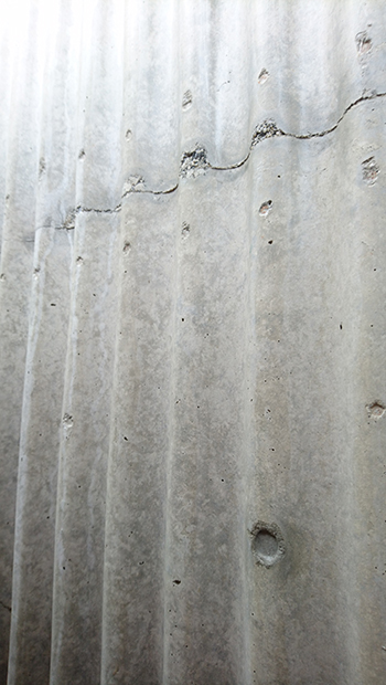 トタン波板の型枠で仕上げられたコンクリート壁。