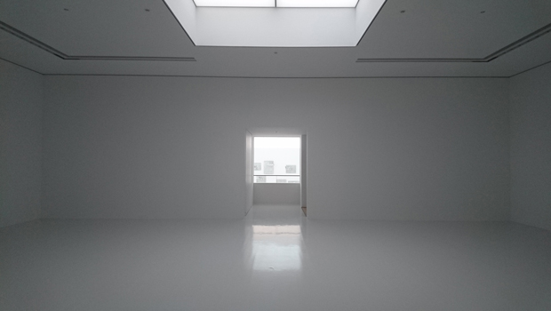 壁、床、天井、全てが白。「外部から何かのパワーがきていることが嫌だった」と言う久門氏はコンセントまでも排除。トップライトから入ってくる自然光の変化がそのまま空間の明暗となる。壁面に《crossfades #1》（2015／2020年）が展示されている。