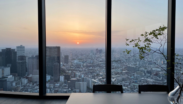 大きな窓からは西新宿の高層ビル群の向こうに沈む夕日が見える。