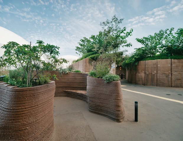 3Dプリンターで作成した、外装パネル（奥）とベンチプランター（手前）。植栽も育ち暑さをしのぐ場にもなっている ©大竹央祐