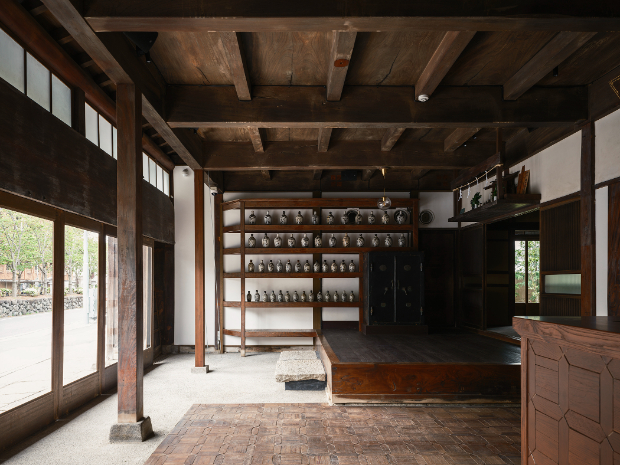 酒屋の面影を残したホール。手前の床板は既存のまま残し、土間とするため剥がしたものをカウンターの壁面に貼っている。　©山内紀人